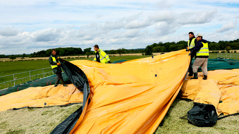 Fire menn som legger silostop toppfilm